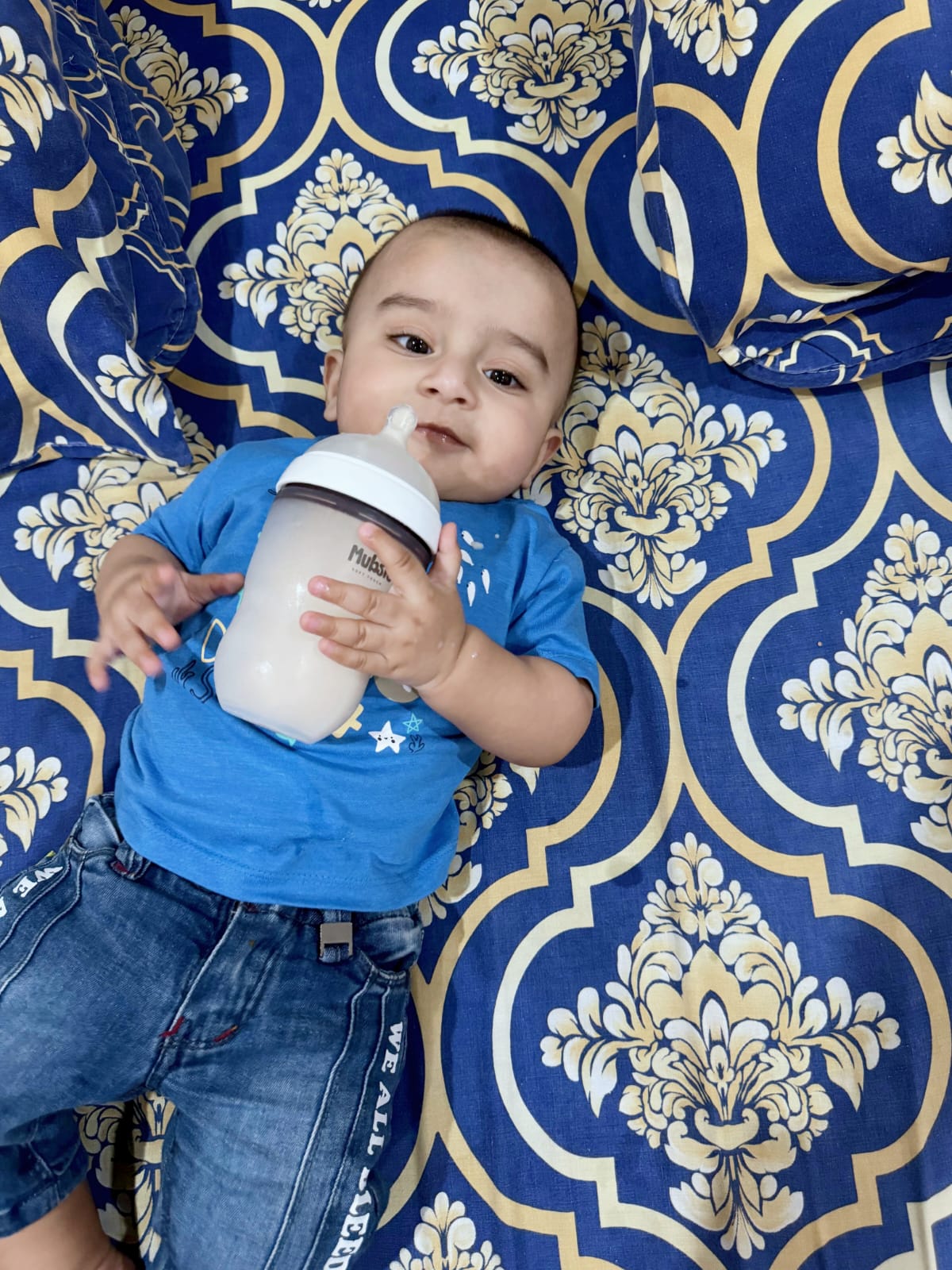 Baby holding Mubsie Bottle